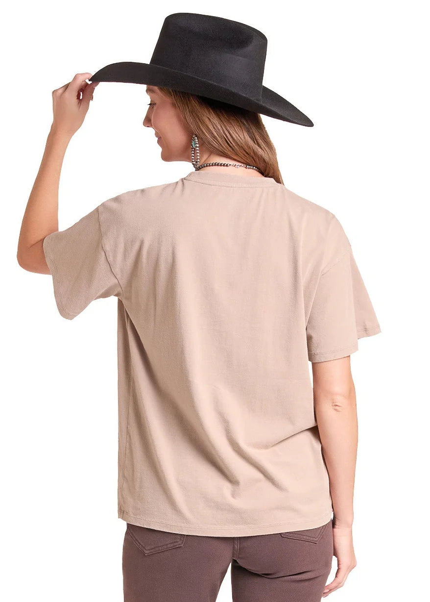 Woman wearing a taupe colored tshirt from Rock&Roll Denim, brown jeans and a black cowboy hat on a white background