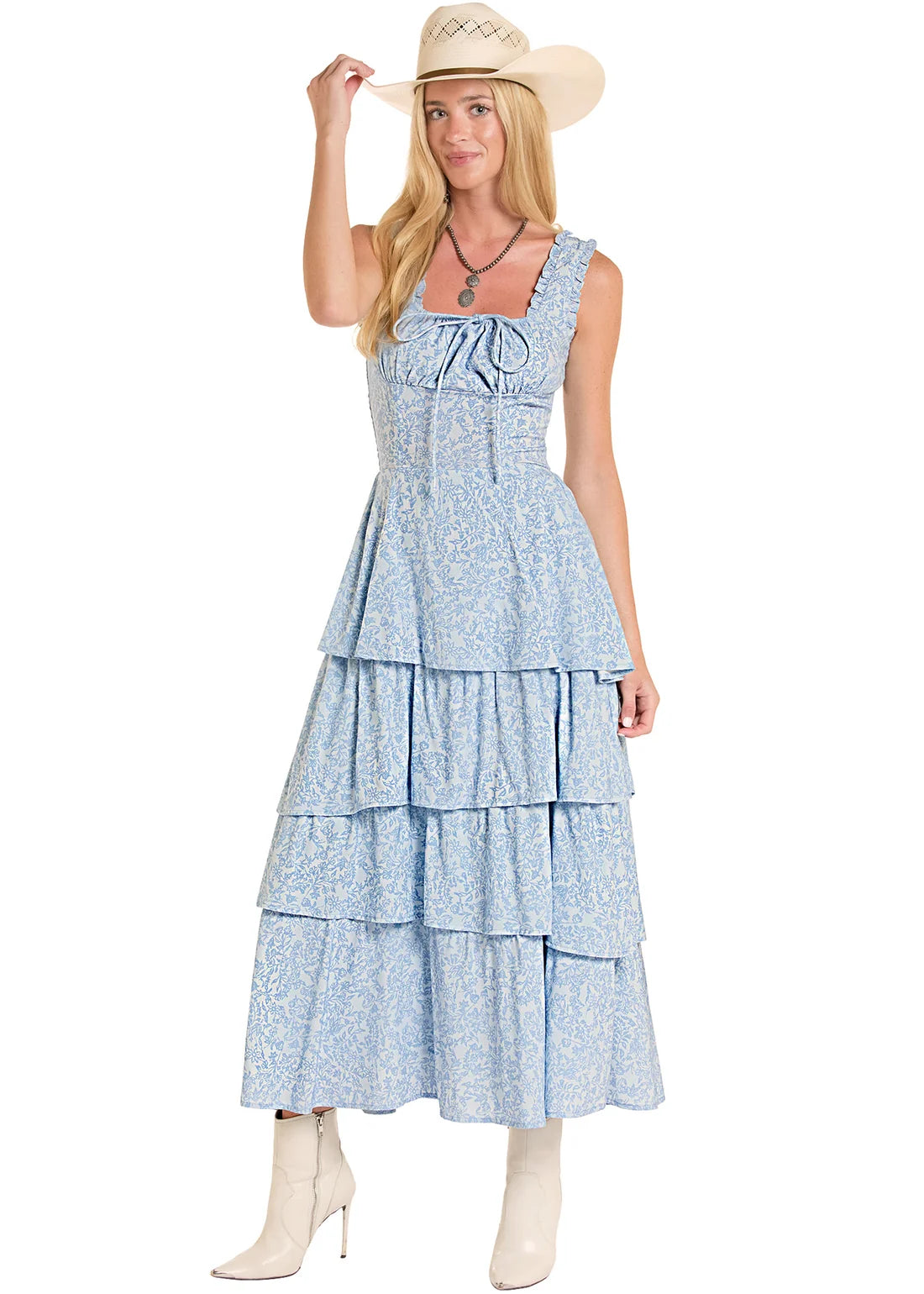 Girl wearing a blue Rock&Roll Denim dress, white boots and a cowboy hat on a white background