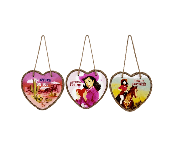 Three heart shaped ornaments with western scenes on them from Ganz on a white background