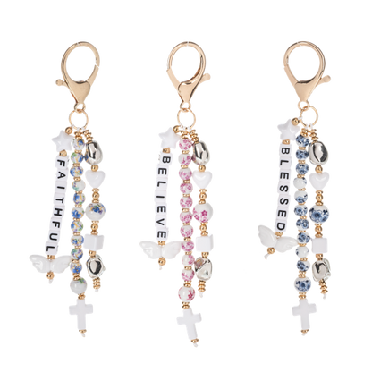 Bag charms from Ganz with inspirational words, beads and clips. On a white background