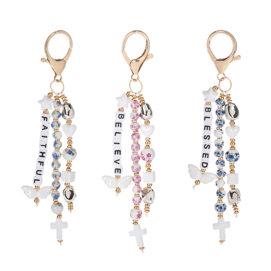 Bag charms from Ganz with inspirational words, beads and clips. On a white background
