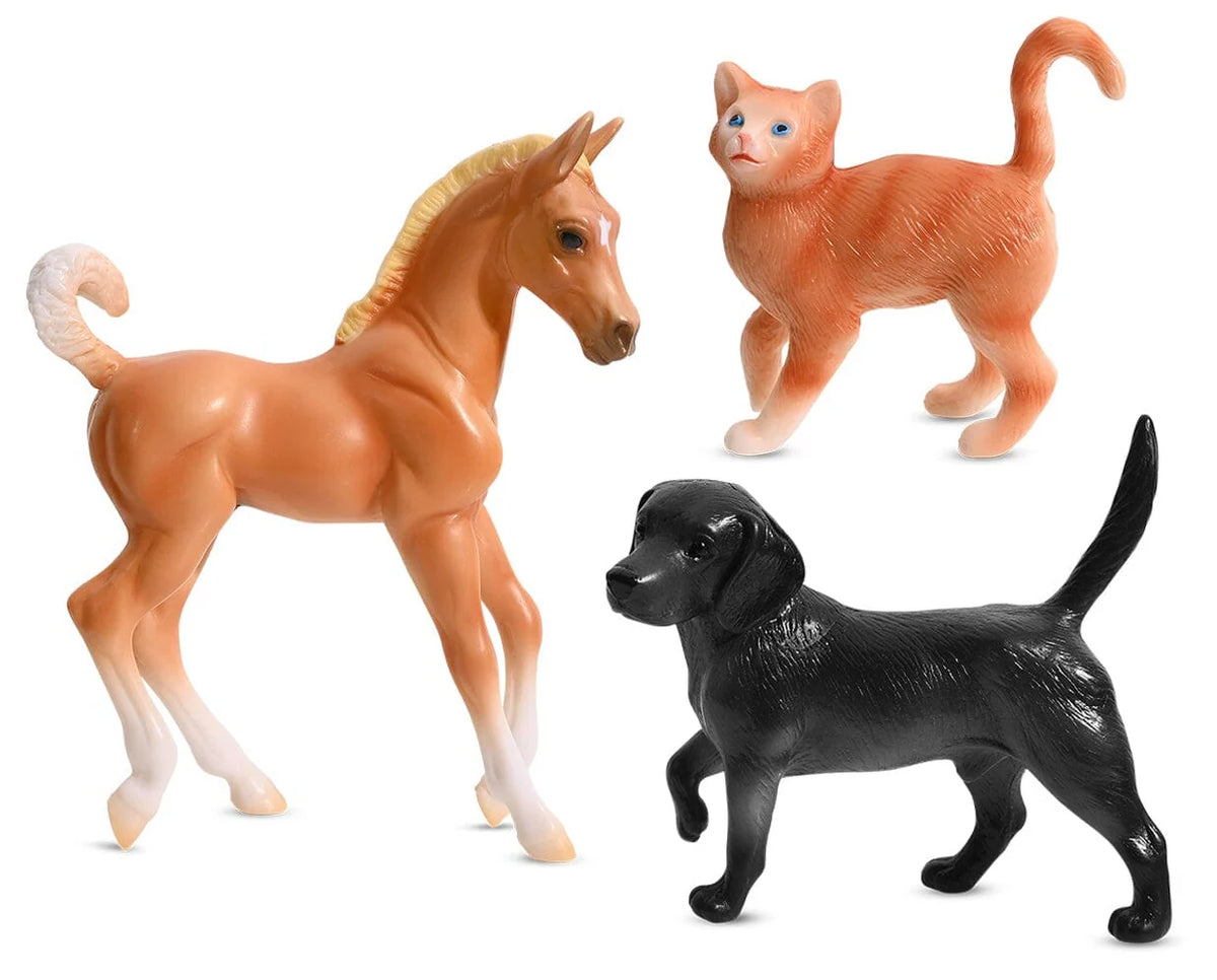Breyer cat, dog and foal figurines on a white background
