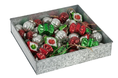 a metal tin from Ganz with holiday ornaments in it on a white background