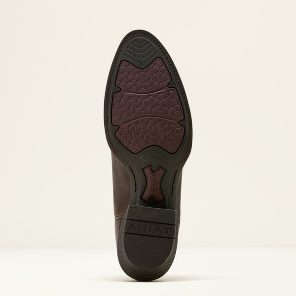 Sole of a brown leather Ariat cowboy boot on a beige background