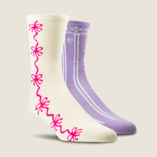 Two Ariat crew socks displayed on a light beige background. The front sock is cream-colored with a bright pink wavy floral pattern running down the side.