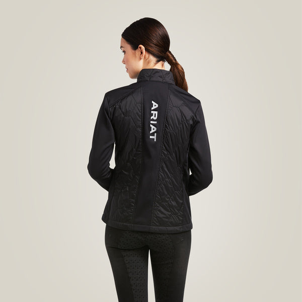 Woman wearing a black jacket with a visible Ariat logo on a light gray background