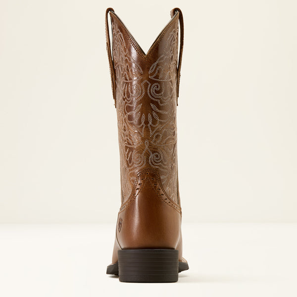 Brown Ariat cowboy boot with intricate embossing on a white background