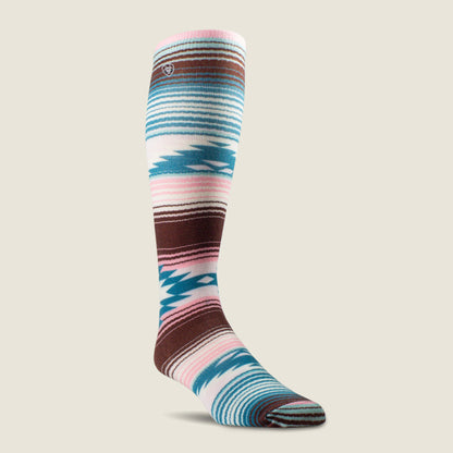 A single knee-high Ariat sock with a Southwestern geometric pattern in brown, teal, pink, and white, shown on a light beige background.