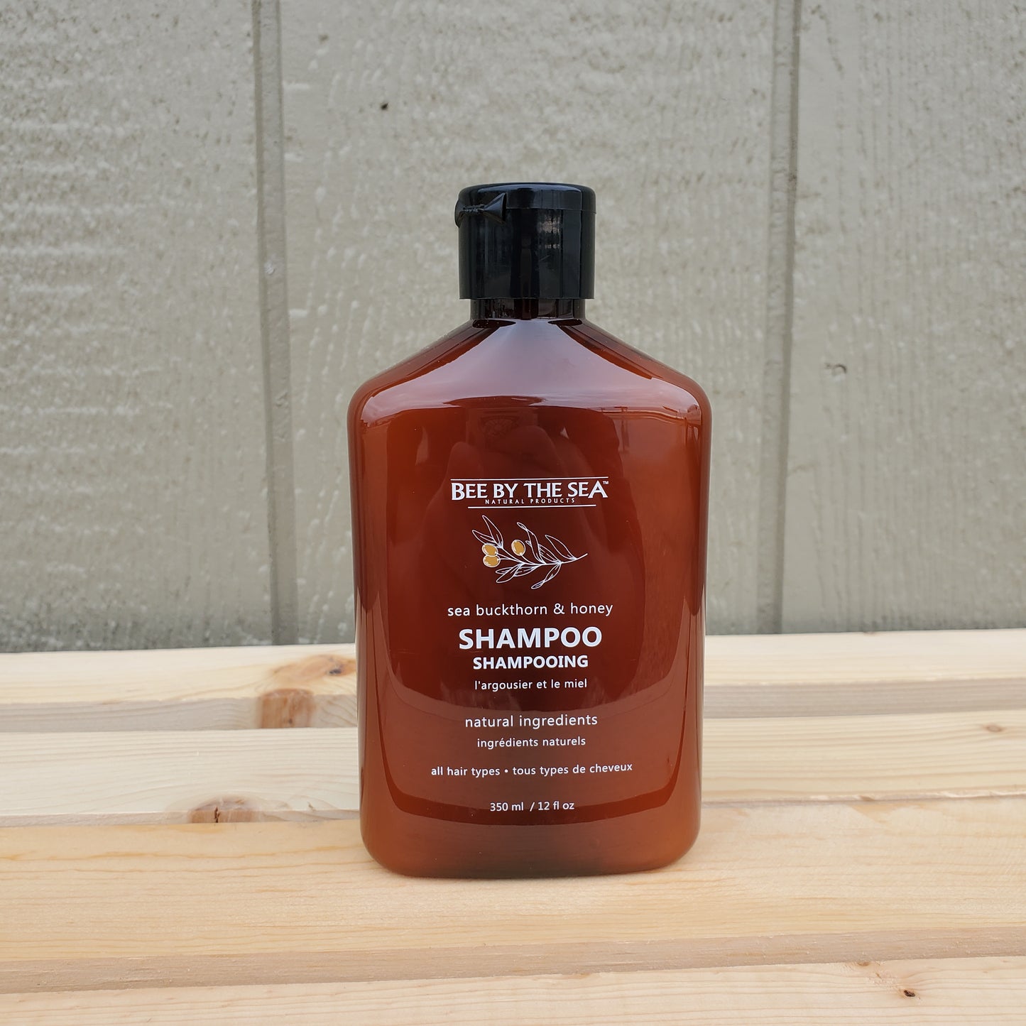 Brown bottle of shampoo on a wooden surface