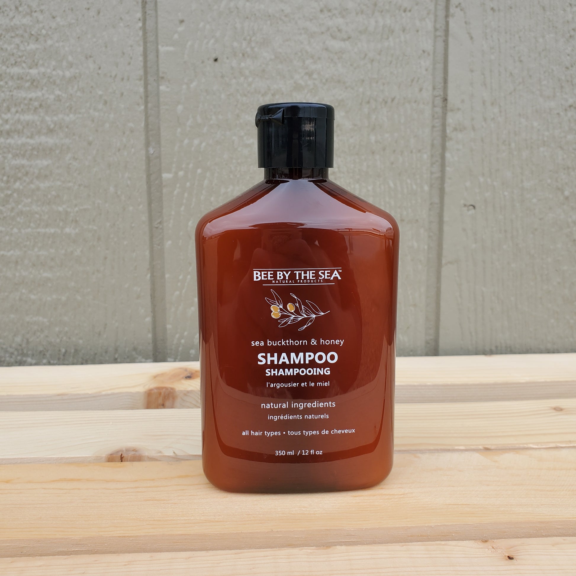 Brown bottle of shampoo on a wooden surface