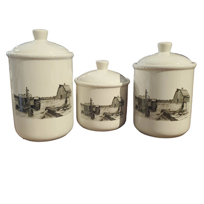 Three white ceramic jars with black illustrations of an old run down farmstead