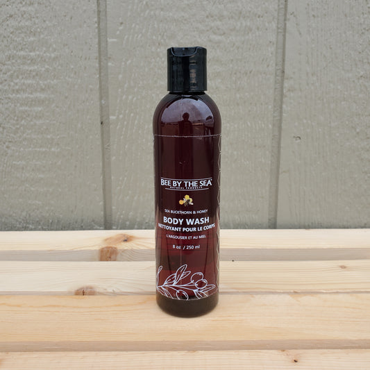 Brown bottle of body wash with a label on a wooden surface