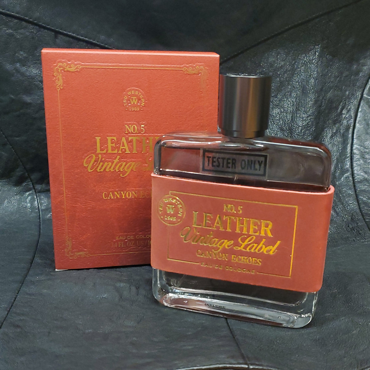 a red box and a bottle of leather vintage label cologne