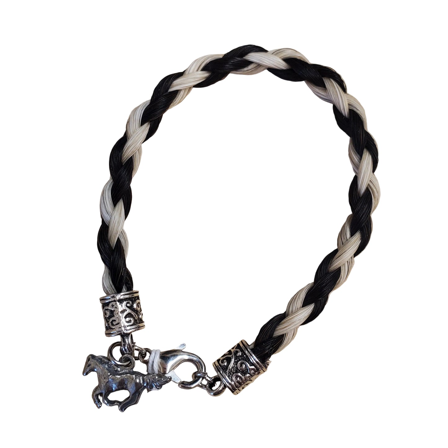 A braided bracelet with black and off-white cords, ornate silver-toned spacers, and a silver horse charm