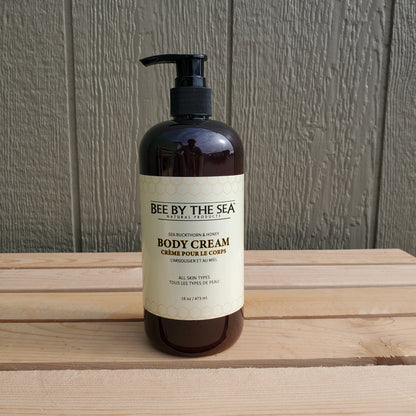 a brown pump bottle of bee by the sea body cream on a wooden background