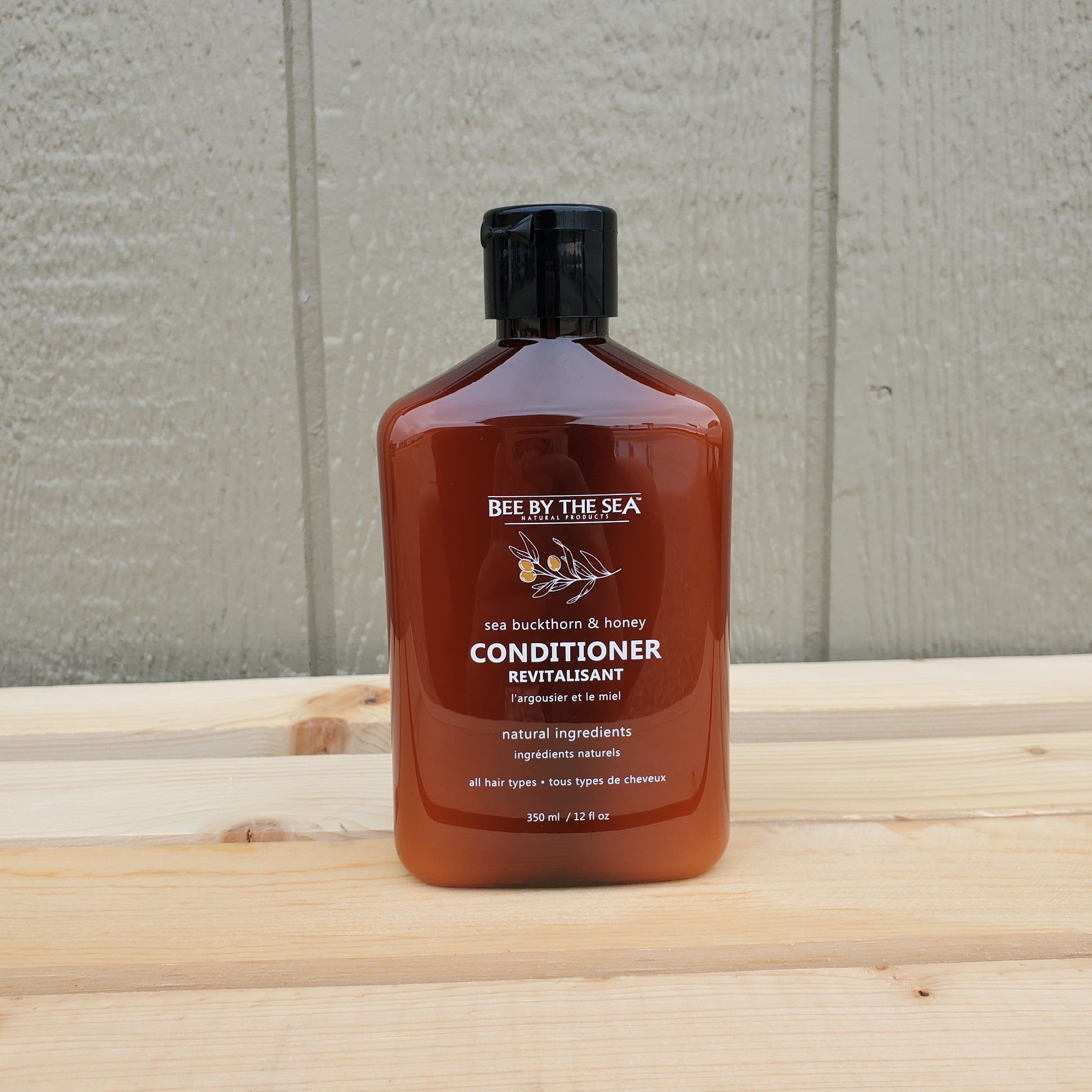 Brown bottle of conditioner on a wooden surface with a neutral background