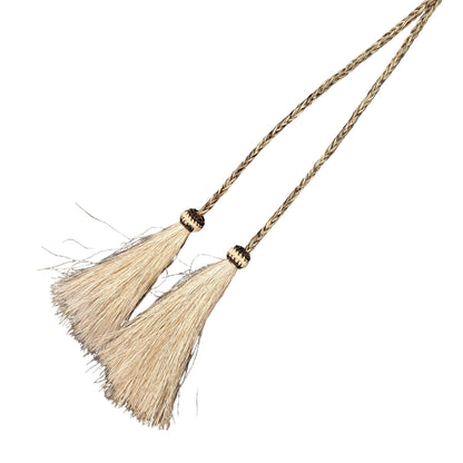A close-up of a braided tan rope accessory with two cream-colored tassels.
