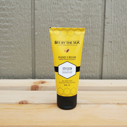 Yellow tube of 'Bee by the Sea' hand cream on a wooden surface
