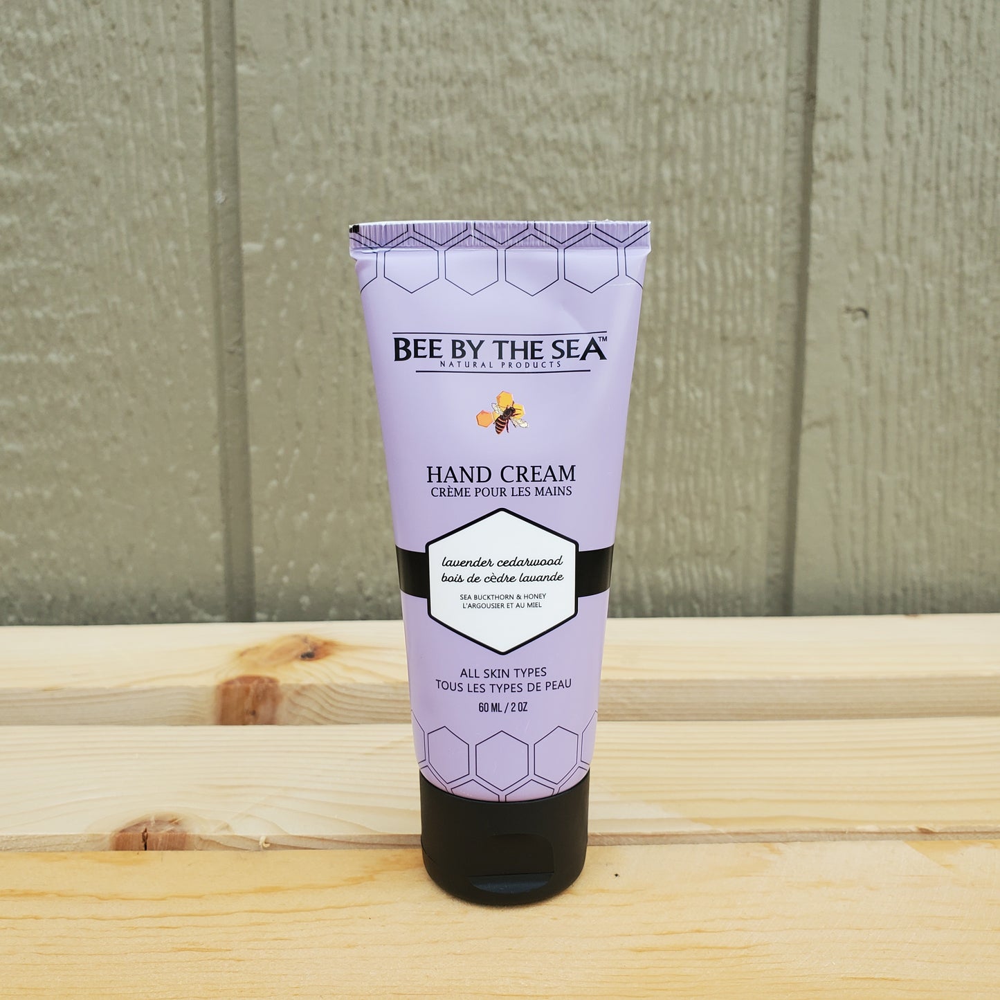 Tube of Bee by the Sea hand cream on a wooden surface