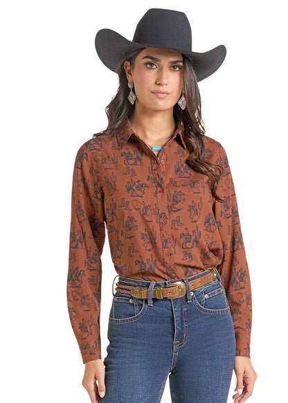 woman wearing a brown Panhandle Slim shirt with print on it, blue jeans and a black cowboy hat on a white background