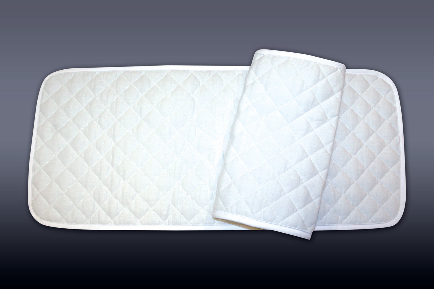 A pair of white quilted standing leg wraps for horses.