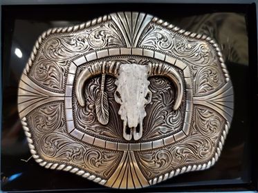 a rope edge belt buckle with a steer skull that is white