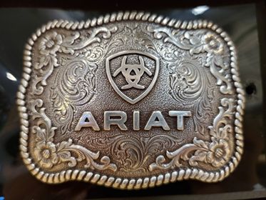 Belt buckle with rope edge and Ariat logo on a black background