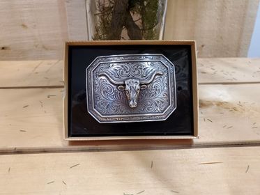 Belt buckle with steerhead and a smooth edge on a wooden background