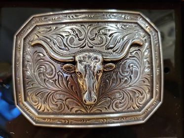 smooth edge buckle with a steerhead on a black background