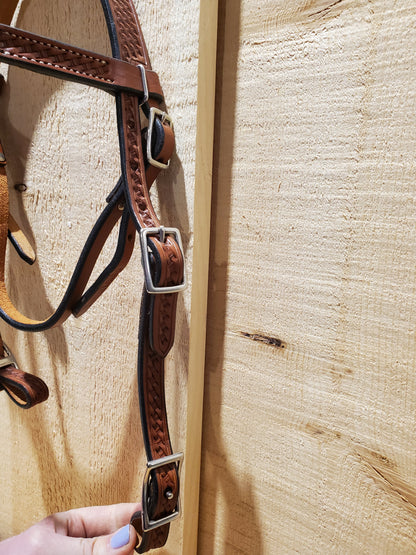 a close up of a leather bridle on a wooden background