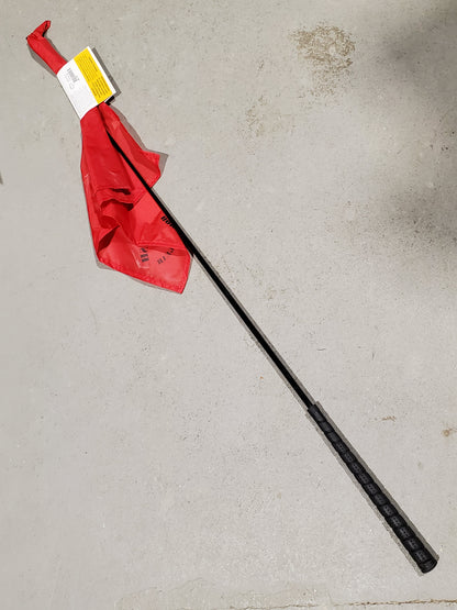 a red flag on the end of a black stick on a cement background