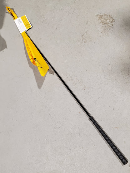 a yellow flag on the end of a black stick on a cement background