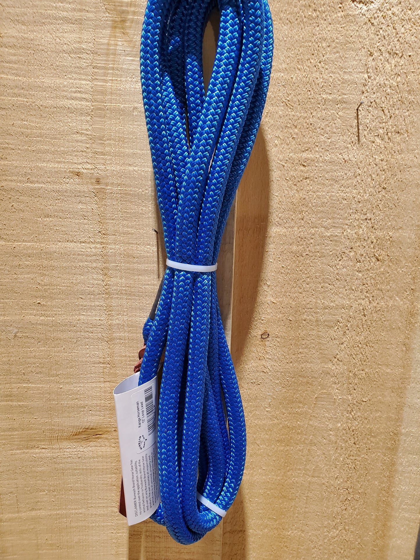 A 12-foot blue lead rope with a loop end and a leather popper on the end, displayed against a wooden background.
