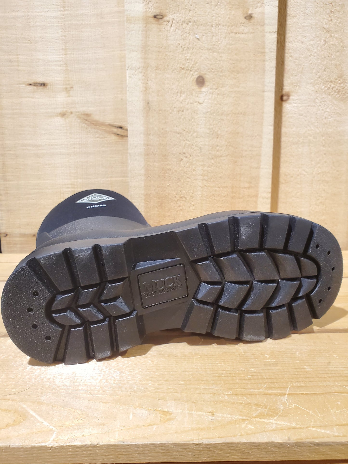 the outsole of a rubber boot on a wooden background