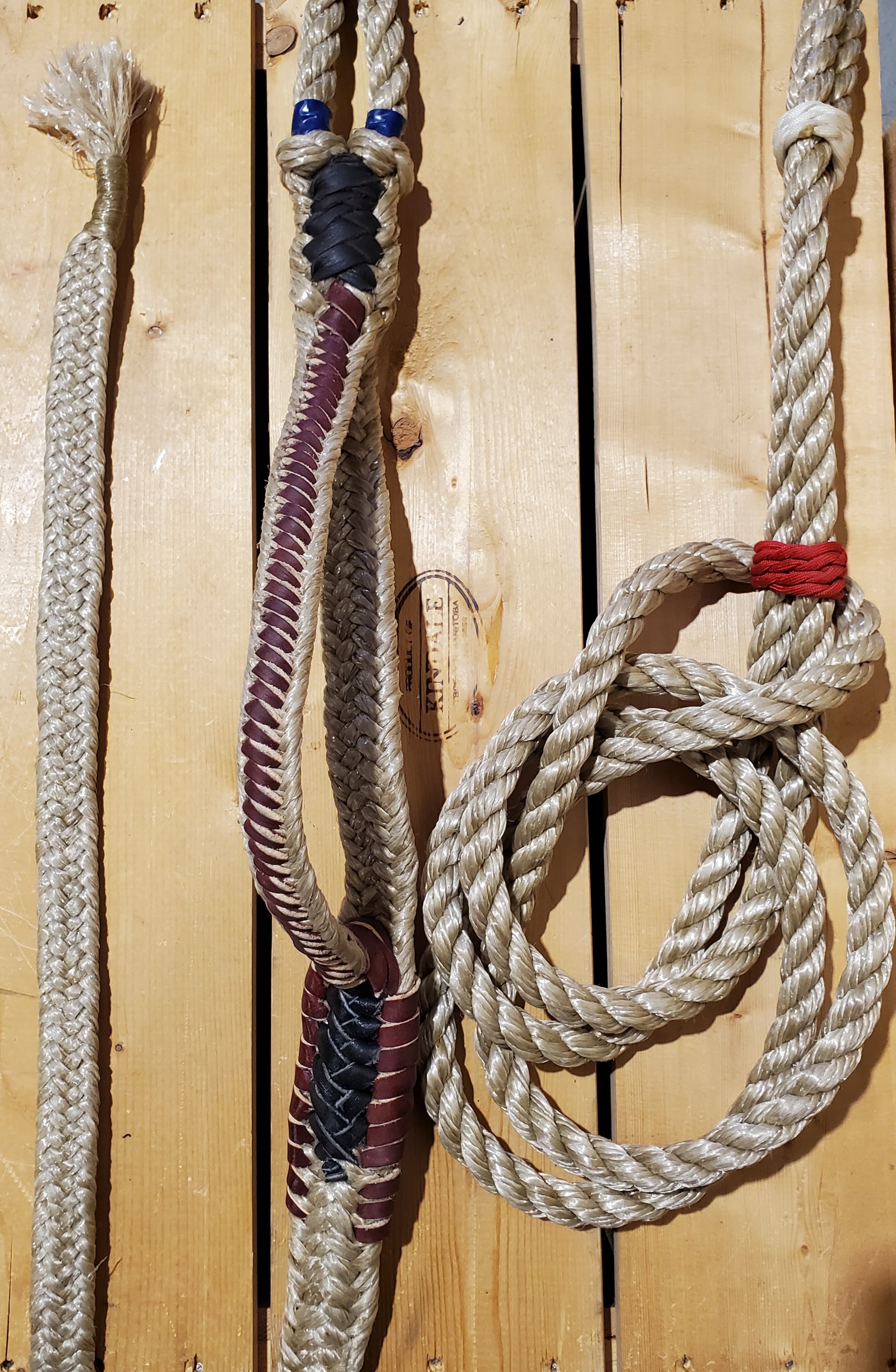 A braided bull ropes with varying colors displayed on a wooden surface.