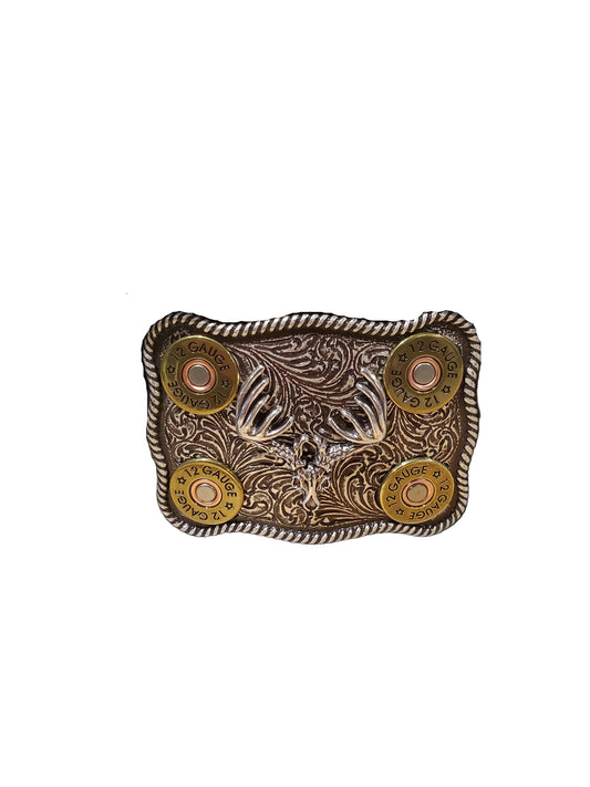 A belt buckle with a buck skull design and 12 gauge caps, featuring rope edge and scrolling, on an antique finish.