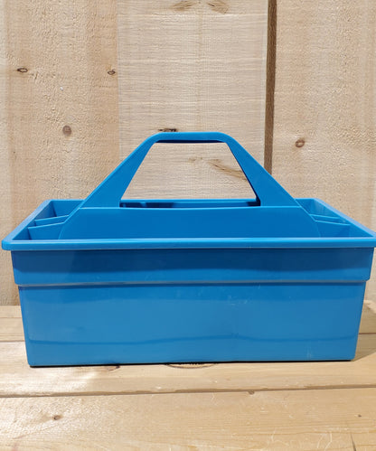 A blue plastic utility tote with a handle, designed to be carried by hand and to fit onto a fence board.