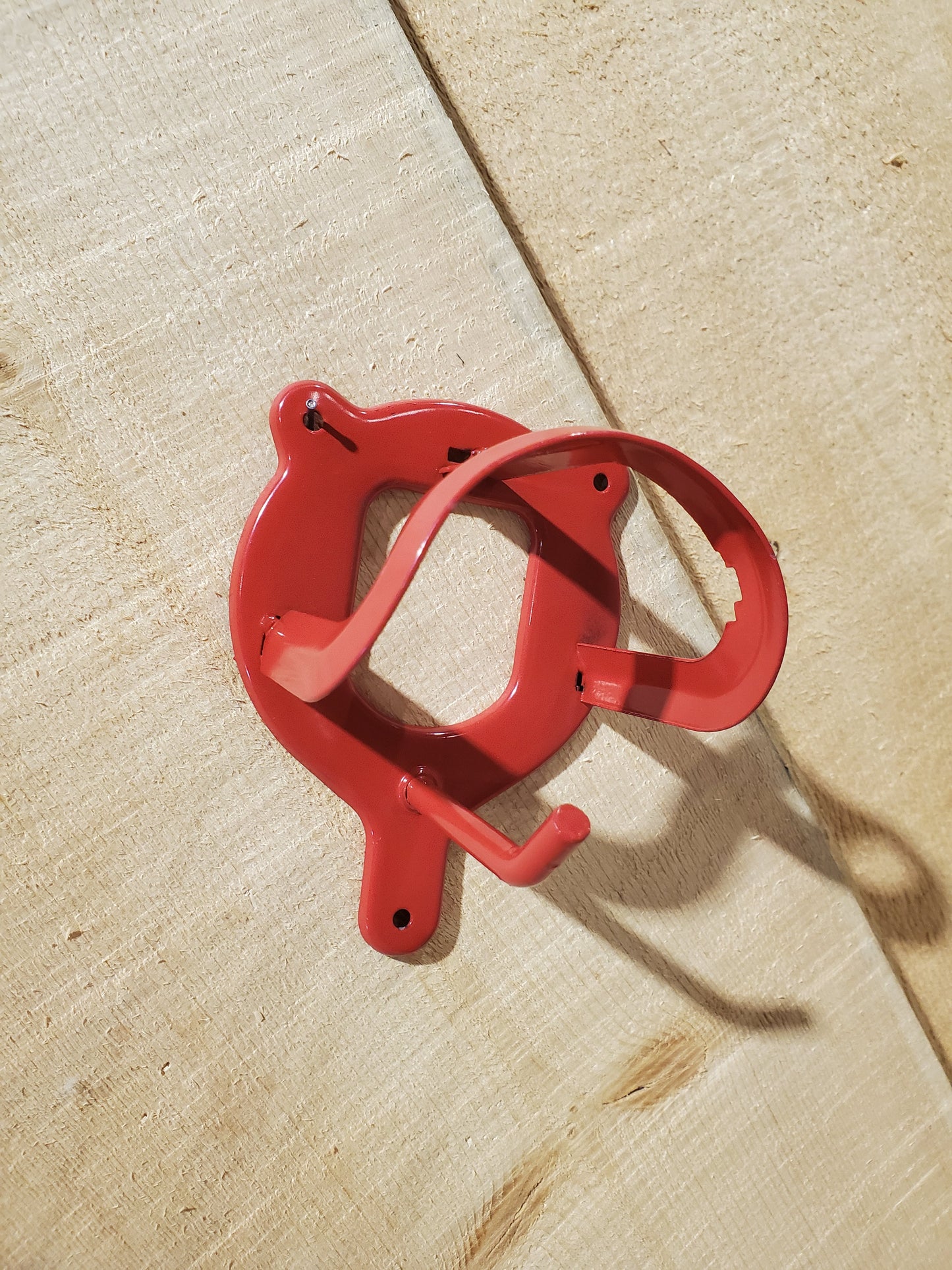 a red hook for hanging horse equipment on a wooden background
