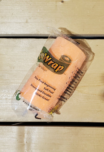 A rolled-up neon orange FlexWrap E-Z Tear bandage, secured with a label that has the product name and details.