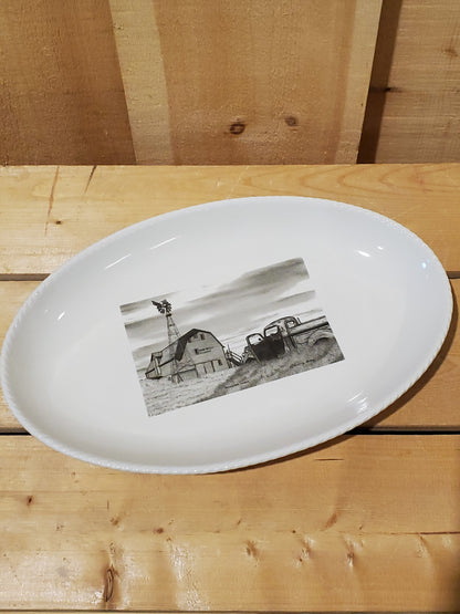 A white serving platter with a printed illustration featuring an old truck and barn