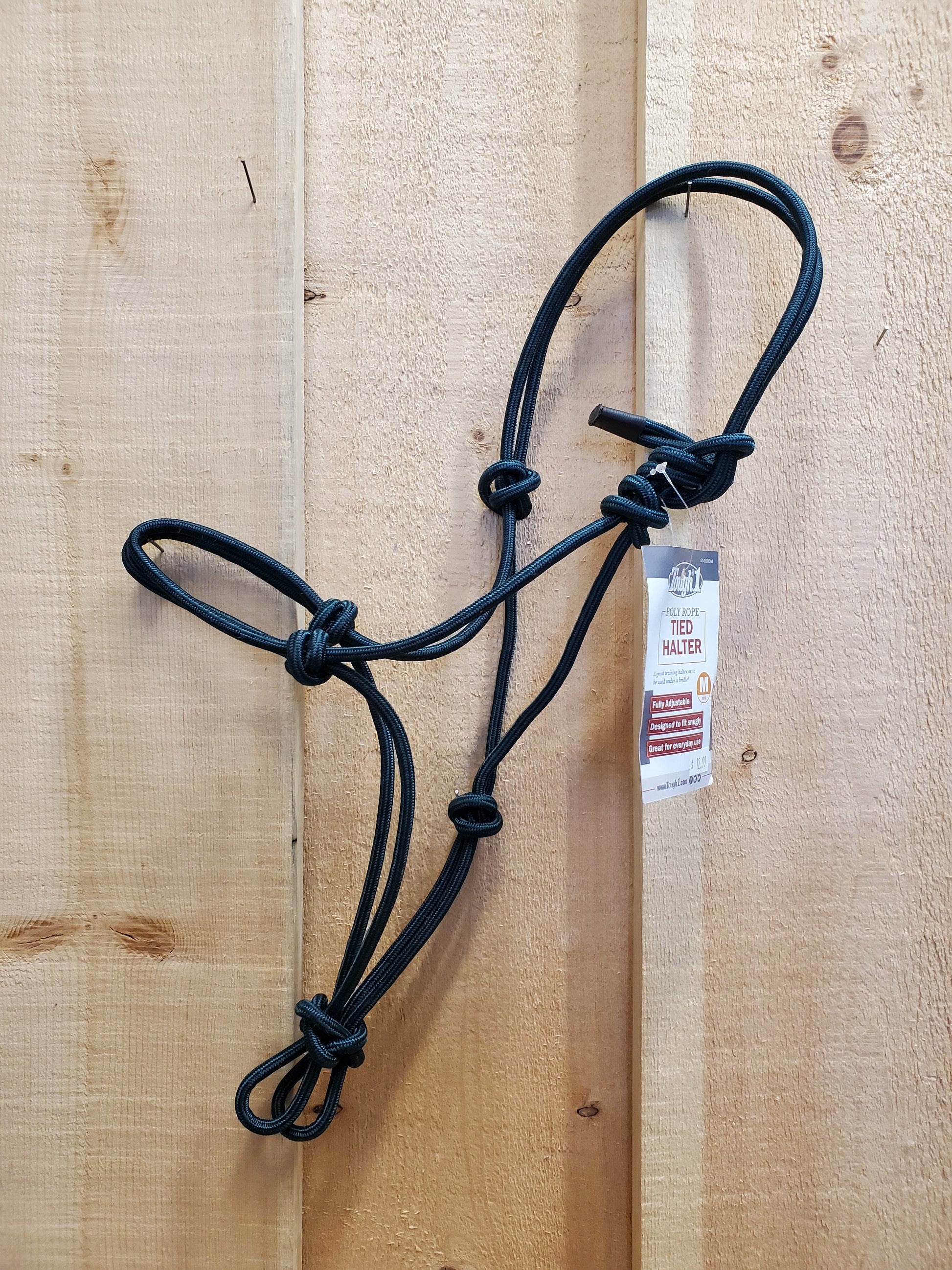 A dark green poly-nylon rope halter hanging against a wooden background.