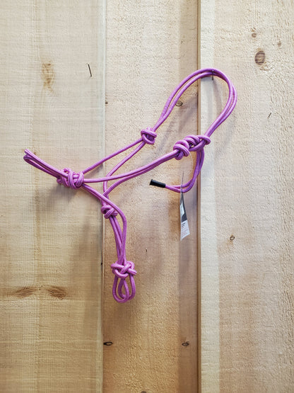 A light pink poly-nylon rope halter hanging against a wooden 