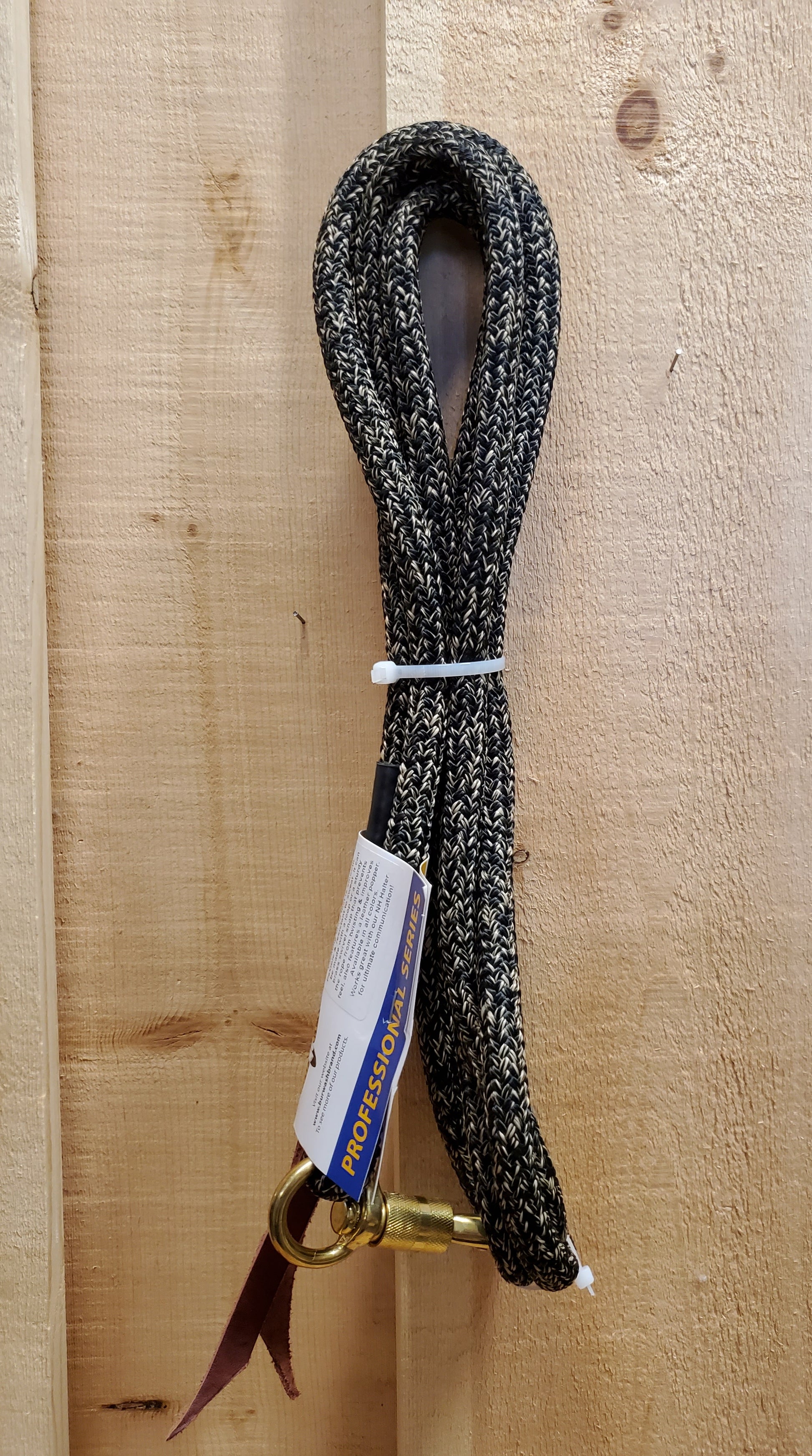 a black and tan 12 foot lead rope with a brass snap on a wooden background