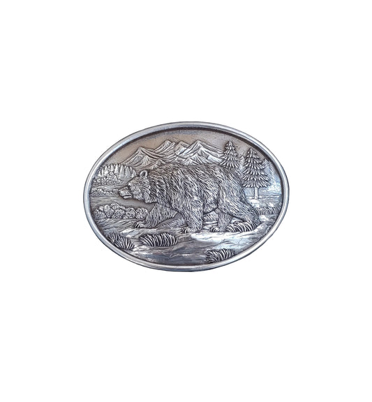 Belt buckle with grizzly bear decoration on a white background