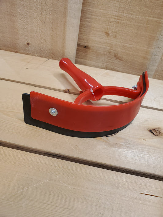 a red and black plastic sweat scraper on a wooden background