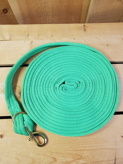 lime green coiled up rope with a brass snap on a wooden background
