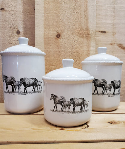 a set of three white ceramic canisters with a western themed black and white design