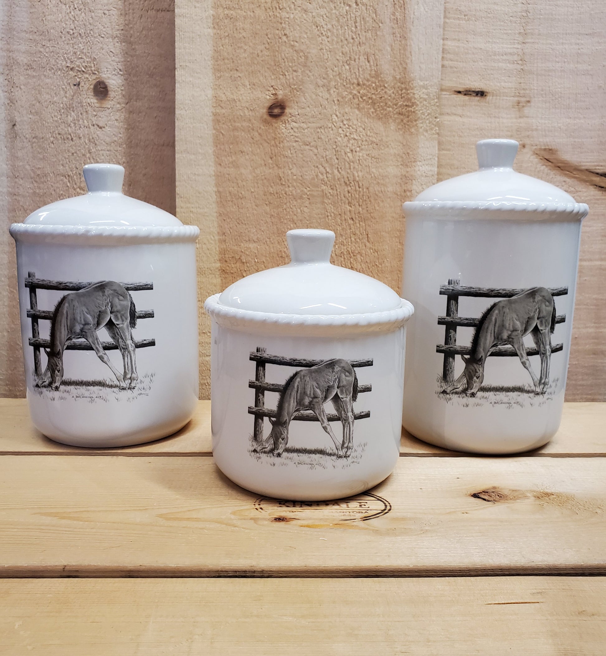a set of three white ceramic canisters with a western themed black and white design