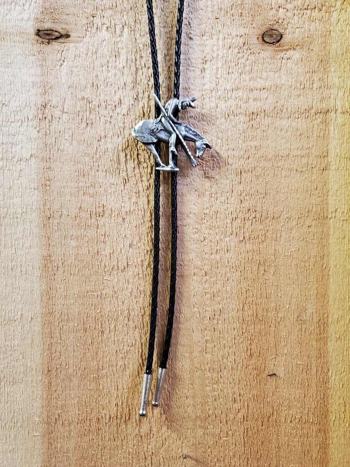 end of the trail bolo tie, also known as last ride, on a wooden background