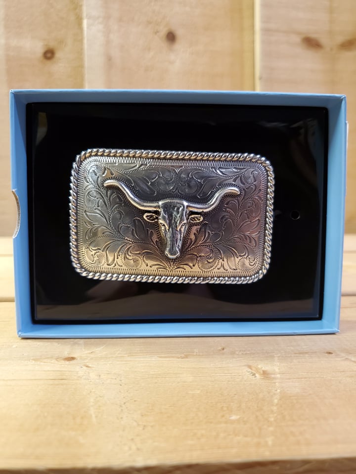 a silver rectangle buckle with a steer head and rope edge detail in a display box on a wooden background